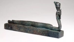 Bronzen mummiekist voor een dier in de vorm van een aal en een cobra met een mensenhoofd dat de dubbele kroon draagt als een voorstelling van de scheppergod Atoem - British Museum Londen